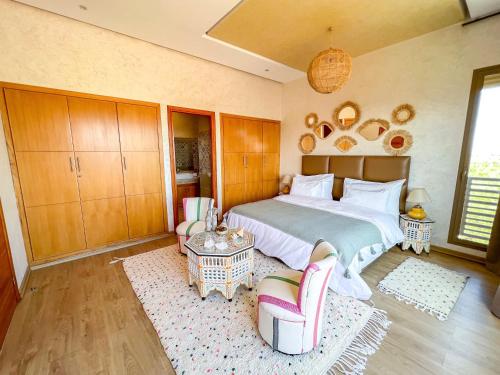 a bedroom with a large bed and two chairs at Riad villa saphir & SPA in Marrakech