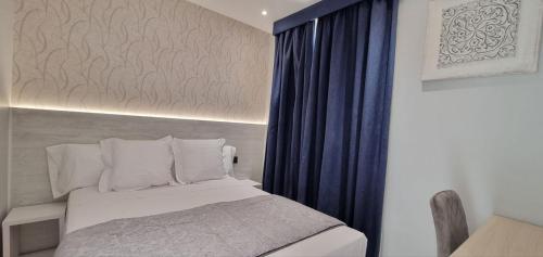1 dormitorio con cama y cortina azul en CH La Petite Maison - Boutique - Madrid, en Madrid