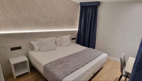 1 dormitorio con cama blanca y cortina azul en CH La Petite Maison - Boutique - Madrid, en Madrid