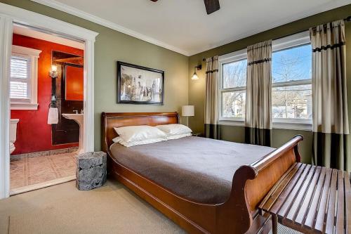 a bedroom with a bed and a bench and windows at 3 - 4 Bdrm Victorian Beach House in Asbury Park