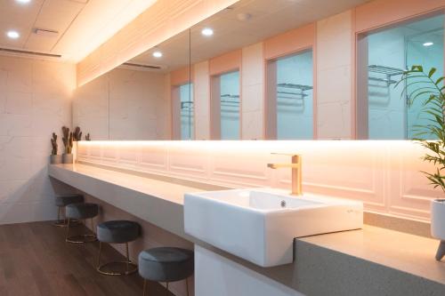 a bathroom with a sink and a mirror at Brosis Hotel in Busan