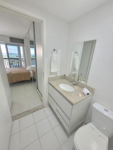 y baño con aseo, lavabo y espejo. en Vision Executive Premium XV, en Brasilia