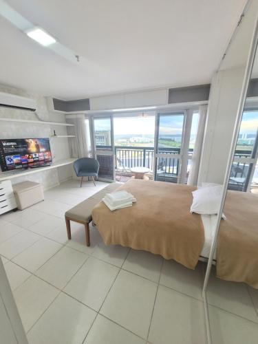 1 dormitorio con 1 cama grande y balcón en Vision Executive Premium XV, en Brasilia