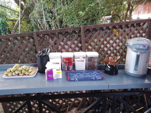 einem blauen Tisch mit Essen und einer Kaffeemaschine darauf in der Unterkunft Funny Riverside Backpackers in Luang Prabang