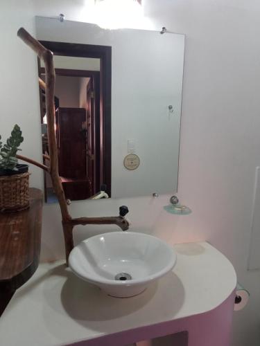 ein Badezimmer mit einem weißen Waschbecken und einem Spiegel in der Unterkunft Cores do Mar Cabanas, Taipu de Fora in Barra Grande