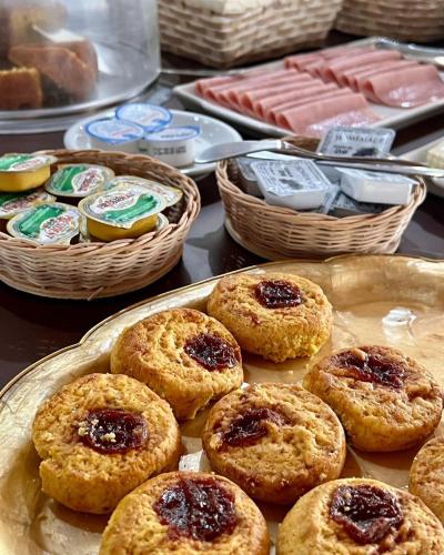 a tray of biscuits with jam on a table with baskets at Hotel Casa Paradiso Guarujá in Guarujá