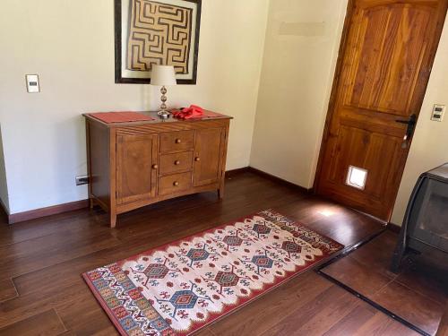 a room with a dresser and a rug next to a door at Tumuñan Lodge in El Llano