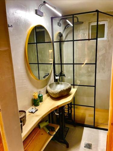 a bathroom with a sink and a shower at Νύμφες Σαλέ Αλκυόνη in Pirá