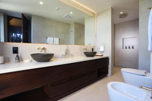 La salle de bains est pourvue de 2 lavabos et d'un grand miroir. dans l'établissement Villa Malolo Levu, à Île de Malolo
