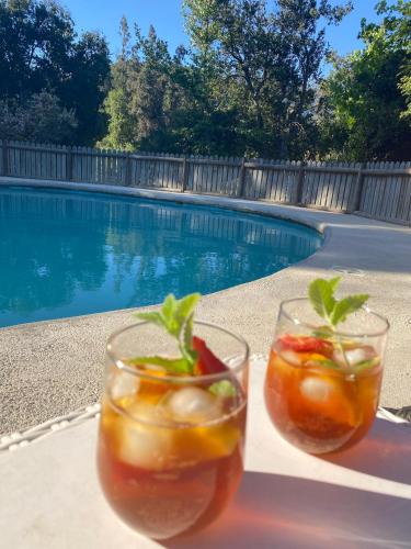 two glasses filled with fruit next to a swimming pool at Tumuñan Lodge in El Llano