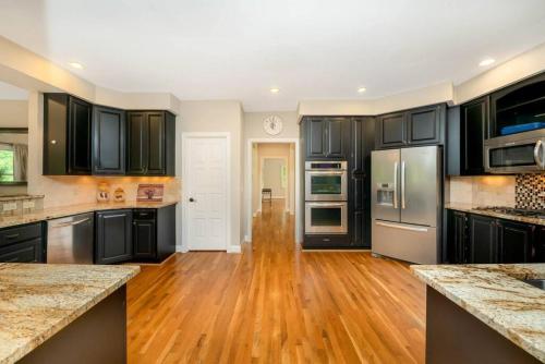 a kitchen with black cabinets and a wooden floor at 5755 Butler Warren Cheerful 6-Bedroom Villa with fishing pond in Jericho