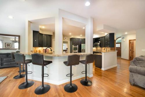 a kitchen and living room with a counter and stools at 5755 Butler Warren Cheerful 6-Bedroom Villa with fishing pond in Jericho
