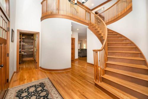 a wooden spiral staircase in a home with wooden floors at 5755 Butler Warren Cheerful 6-Bedroom Villa with fishing pond in Jericho