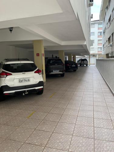 een parkeergarage met auto's erin bij Apartamento 2 Guarujá enseada 2 dorm, 200m praia Ed Carpentier in Guarujá
