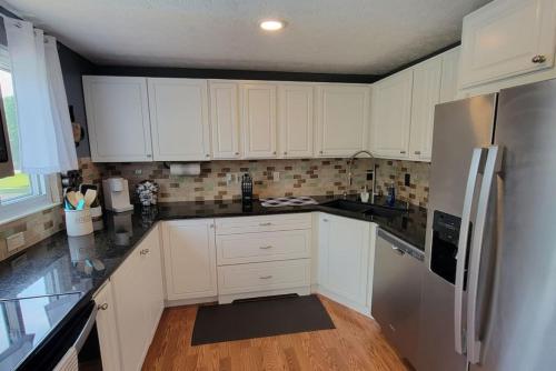 a kitchen with white cabinets and a stainless steel refrigerator at 1349 Jennings court Private Pool, Fire pit, BBQ A FUN place to RELAX in Mason