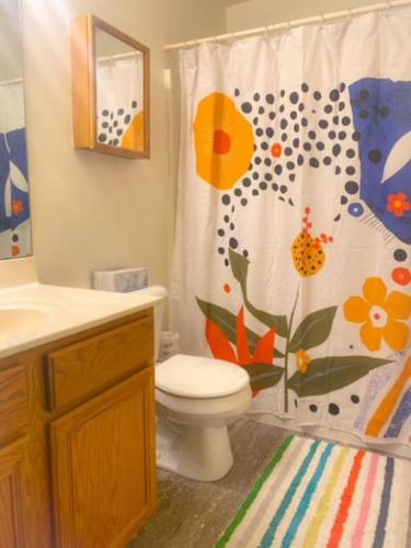 a bathroom with a toilet and a shower curtain at 240 Overbrook NEW Franks funky and fashionable furnished home in Monroe