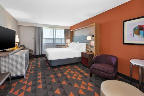 um quarto de hotel com uma cama e uma cadeira em Holiday Inn St Johns, an IHG Hotel em St. John's