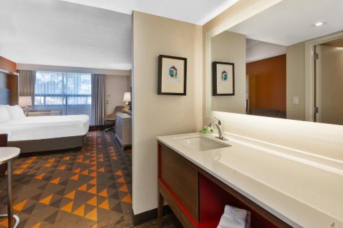 La salle de bains est pourvue d'un lavabo et d'un lit dans la chambre. dans l'établissement Holiday Inn St Johns, an IHG Hotel, à Saint-Jean