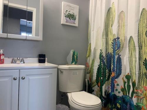 baño con aseo y cortina de ducha con cactus en Hidden Two BDR Gem in Middletown w Private Laundry, en Middletown