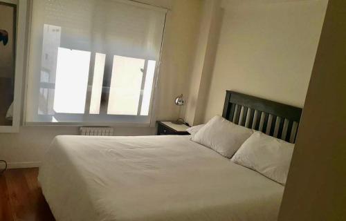 1 dormitorio con 1 cama blanca grande y ventana en 3 amb Abadia cochera techada SOLO CON RESERVA en Buenos Aires