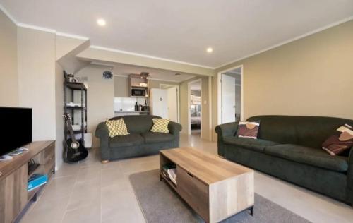 a living room with two couches and a coffee table at HarbourView Hotel in Raglan