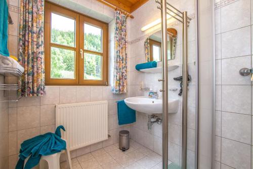 La salle de bains est pourvue d'un lavabo et d'un miroir. dans l'établissement Ferienhaus Niedermoser, à Leogang