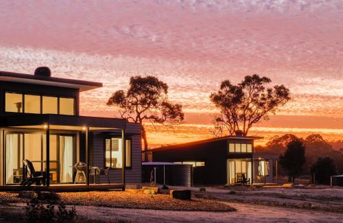 a house with the sunset in the background at Ruse Estate Retreat Margaret River in Rosa Glen