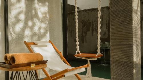 a chair and a swing in a room at Annora Villas Seminyak in Seminyak