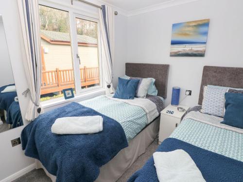 a bedroom with two beds and a window at The Retreat in Narberth
