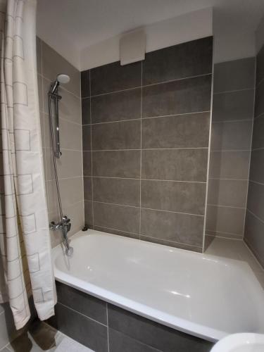 a bathroom with a white tub and a shower at SDP Marina Apartment in Budapest
