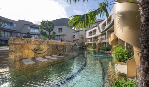 een zwembad in het midden van een binnenplaats met gebouwen bij Metadee Concept Hotel in Kata Beach