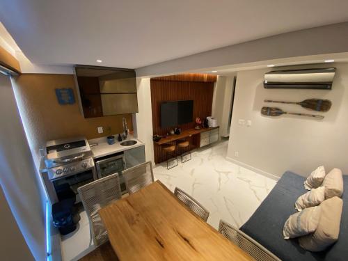 a kitchen and living room with a table and chairs at FLAT PRAIA DOS CARNEIROS - Eco Resort Praia dos Carneiros ao lado da Igrejinha in Rio Formoso