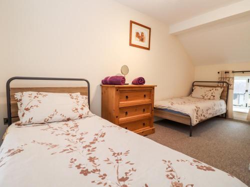 a bedroom with a bed and a dresser at The Stables in Chipping Norton