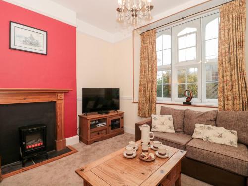a living room with a couch and a fireplace at 3 Old Police Station in Dunster