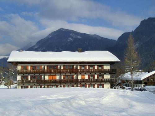 a large building with snow on top of it at Ferienwohnung Dillmann in Sachrang