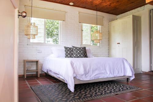 a bedroom with a bed in a room with windows at Finca Hotel Santana in Montenegro