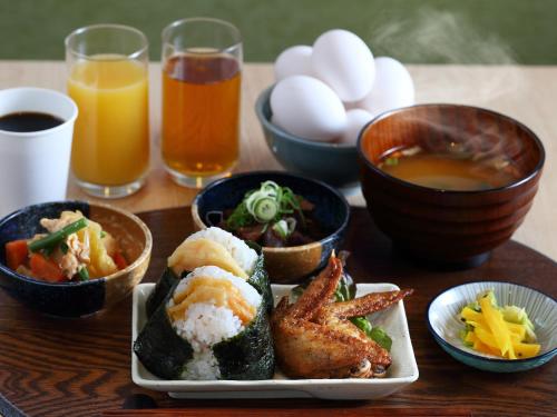 una mesa de madera con un plato de comida y algunas bebidas en Henn na Hotel Express Nagoya Fushimi Ekimae, en Nagoya