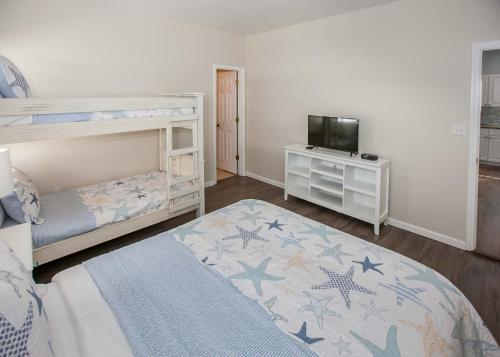 a bedroom with a bunk bed and a television at Poseidon Palace in Sand Landing