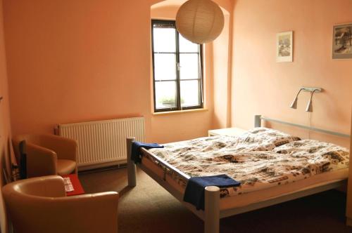 1 dormitorio con 1 cama, 1 silla y 1 ventana en Hotel Na Velké hospodě, en Sedlice