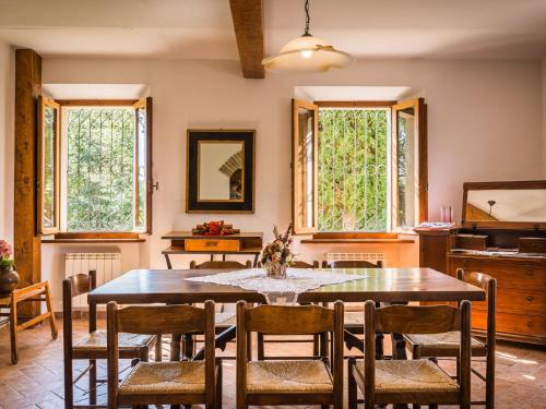 uma sala de jantar com mesa, cadeiras e janelas em Belvilla by OYO Villa Sapori em Pergola