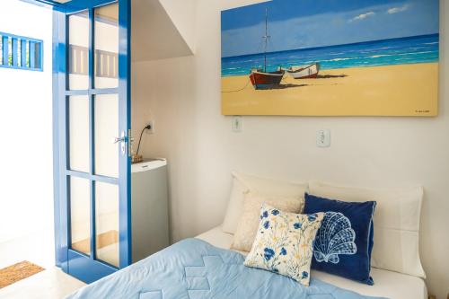 a bedroom with a bed and a painting on the wall at Villa Hortencia Trancoso in Trancoso