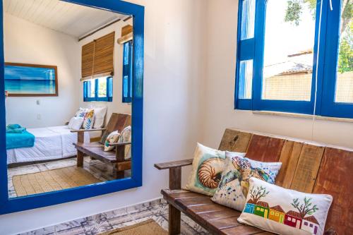 a mirror in a room with a bench and a bedroom at Villa Hortencia Trancoso in Trancoso