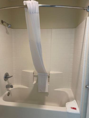 a bathroom with a tub and a shower with a shower curtain at Econo Lodge Inn & Suites Sweetwater I-20 in Sweetwater