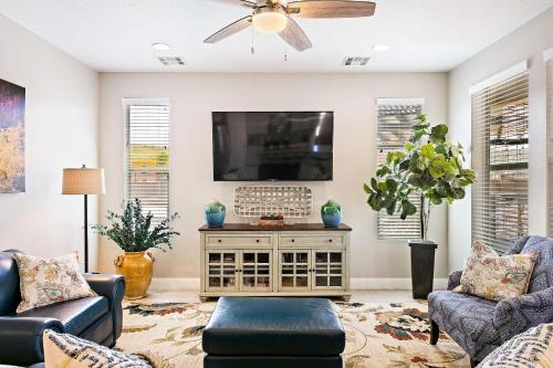 a living room with a tv and a couch and chairs at Zion Poolhouse home in Washington