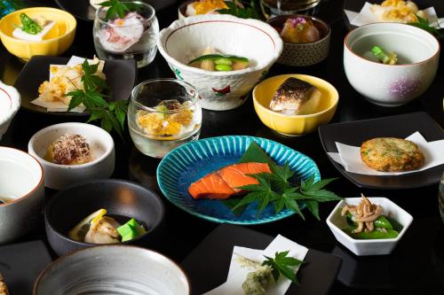 a table full of bowls of food on a table at Kyoto Yamashina Hotel Sanraku in Kyoto