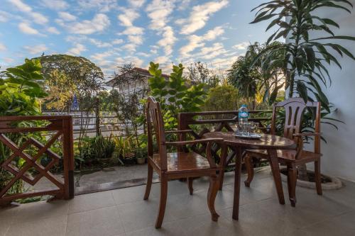 a patio with a table and chairs on a balcony at BABA Guesthouse in Don Det