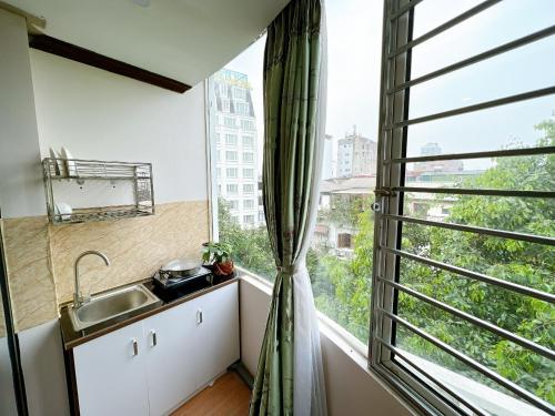 河內的住宿－T - Apartment，一个带水槽和大窗户的厨房