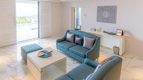 a living room with a couch and chairs and a table at Miyakojima Kurima Resort Seawood Hotel in Miyako Island