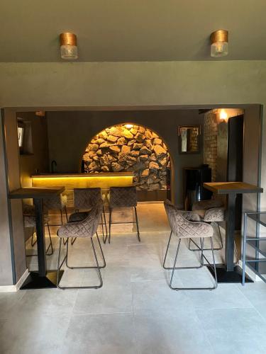 a restaurant with a table and chairs in front of a stone wall at Villa Lovran, heated pool and Spa in Lovran