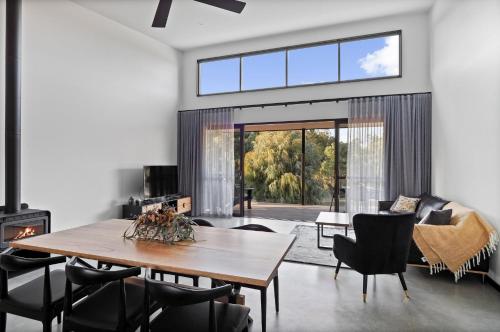 a living room with a table and a fireplace at Ruse Estate Retreat Margaret River in Rosa Glen
